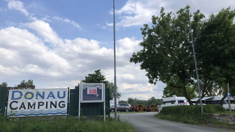 Eingang zum Donau Campingplatz mit Wohnwagen und Bäumen., © Donau NÖ Tourismus