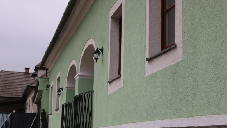 Grünes Gebäude mit weißen Fensterrahmen und Laternen., © Haus Donau, Hr. Benesics