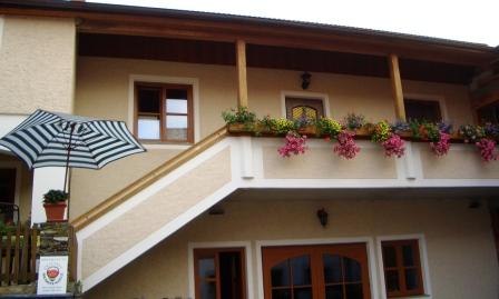 Haus mit Balkon, Blumen und gestreiftem Sonnenschirm., © Schütz Hermine