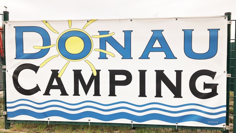 Werbeschild für Donau Camping mit Sonne und Wellenmotiv., © Donau NÖ Tourismus GmbH