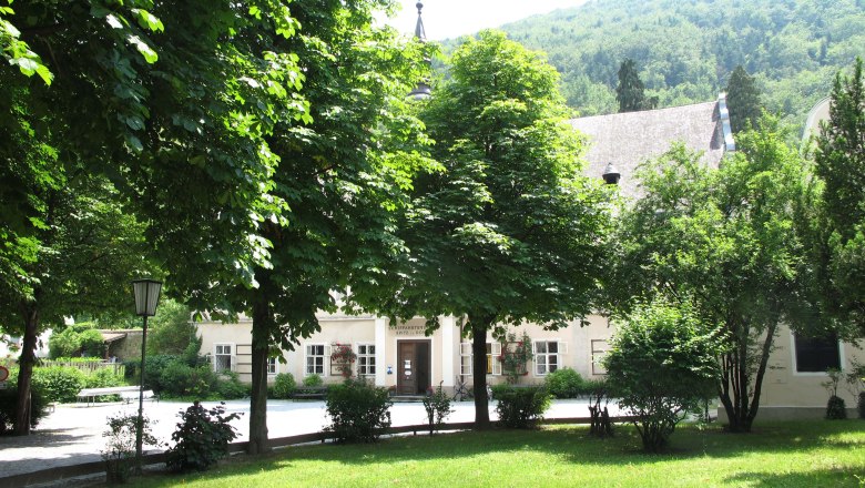 Grüner Park mit Bäumen vor einem historischen Gebäude im Hintergrund., © Donau NÖ Tourismus/BF