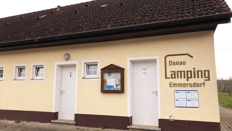 Gebäude mit Schriftzug 'Donau Camping Emmersdorf', gelbe Fassade, Infotafel., © Donau NÖ Tourismus GmbH