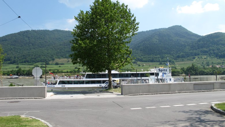 Schiff 'Spitz' an einem Flussufer mit grünen Hügeln im Hintergrund., © Donau NÖ/Birgit Fischer