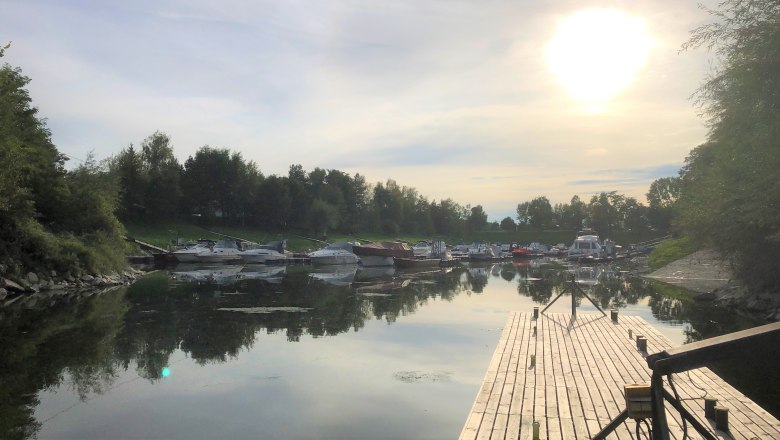 Sonnenuntergang über einem ruhigen Hafen mit Booten und Steg., © Donau NÖ Tourismus GmbH